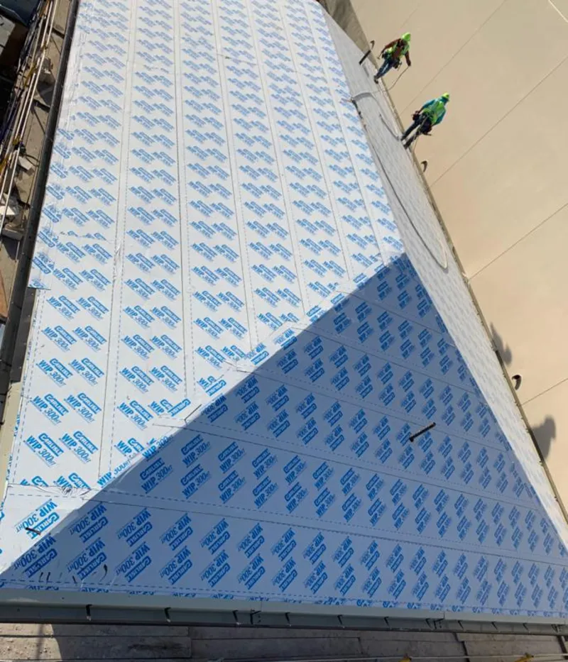 Professional roofers installing underlayment on a metal roof in Lindon